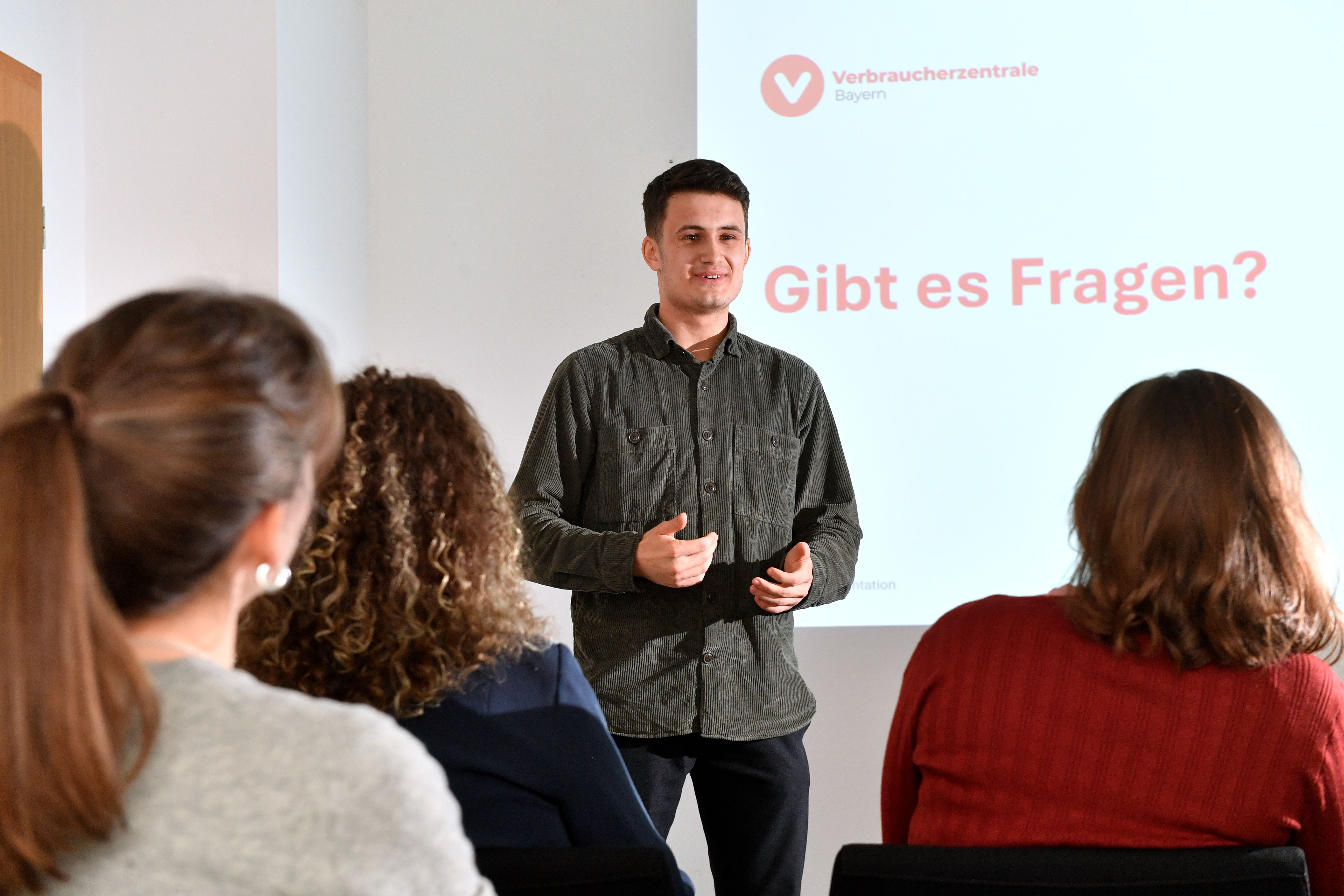 Ein Mann hält einen Vortrag vor Verbraucherinnen und Verbrauchern