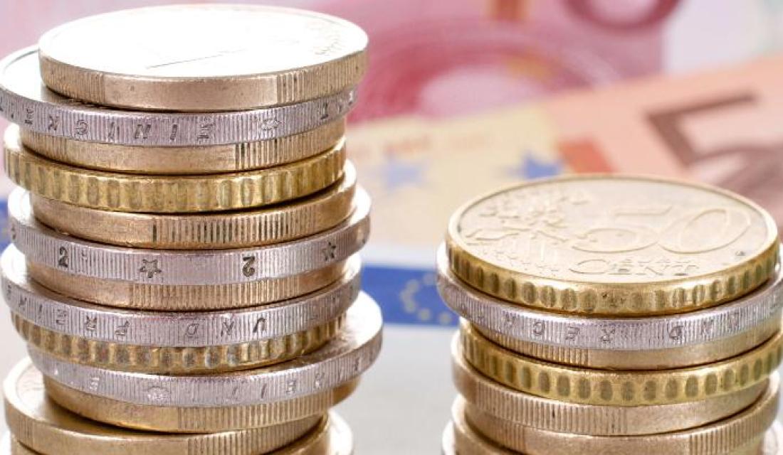 Münzen gestapelt auf Geldscheinen