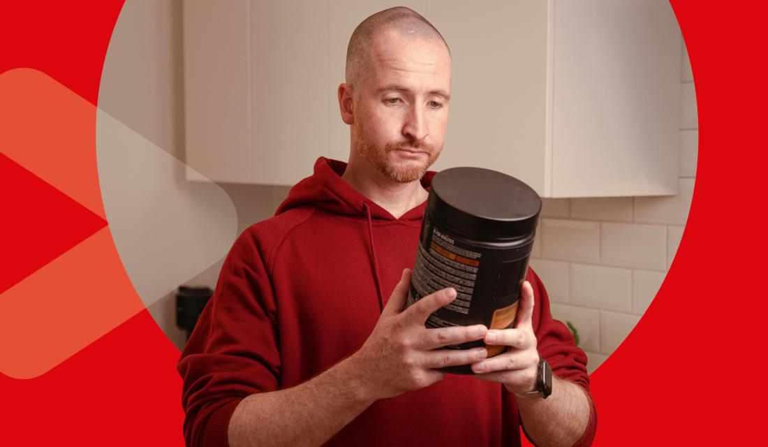 Mann hält Proteinpulver in der Hand