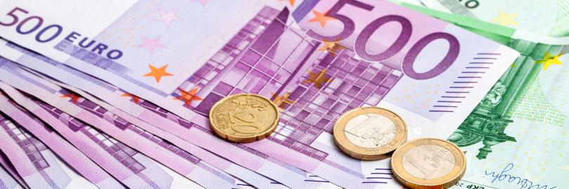 Große Euro-Scheine und Münzen liegen aufeinander.