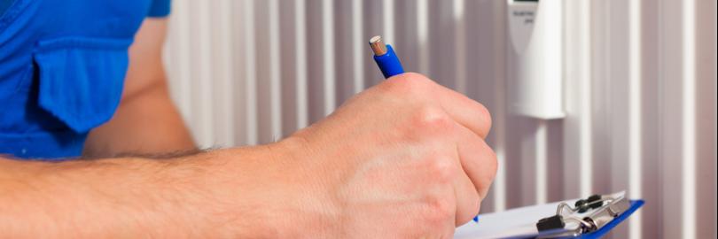 Mann rechnet vor einer Heizung