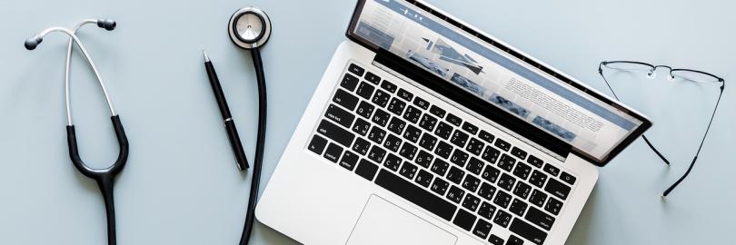Stethoskop auf einem Tisch neben einem Laptop