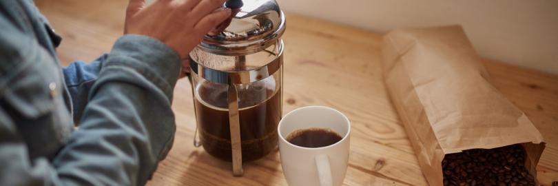 Jemand bereitet Kaffee in einer French Press zu