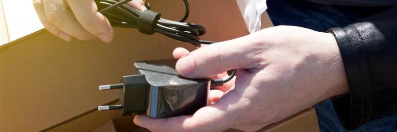 Hände packen aus einer Schachtel ein Kabel aus