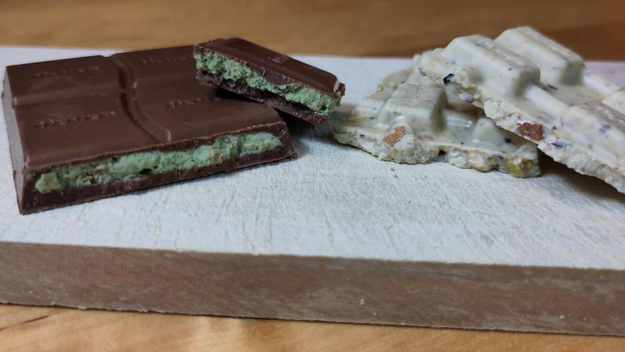 Stücke von Vollmilch- und weißer Dubaischokolade auf einem Schneidebrett