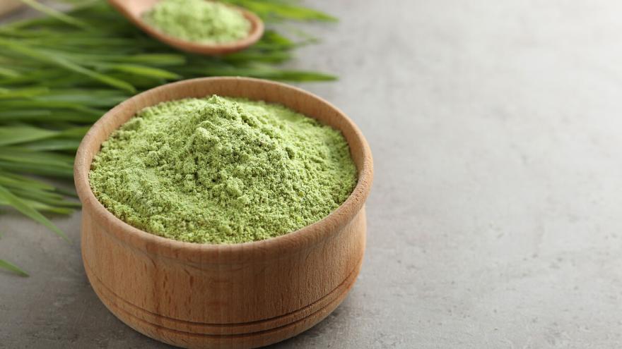 In einer Holzschüssel befindet sich Weizengraspulver.