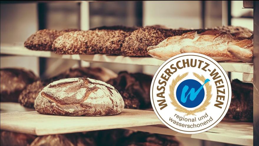 In einem Regal liegen Brotlaibe; auf dem Foto befindet sich das Siegel für "Wasserschutzbrot".