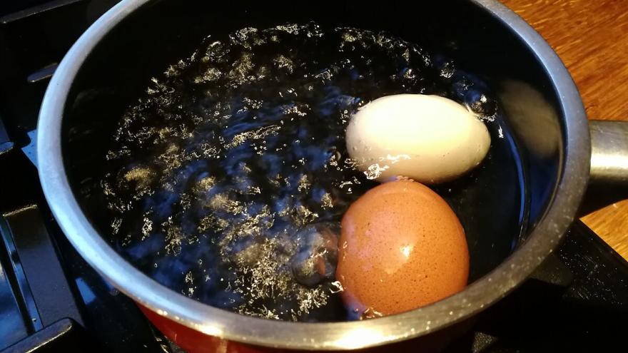 Ein Topf mit kochendem Wasser und zwei Eiern