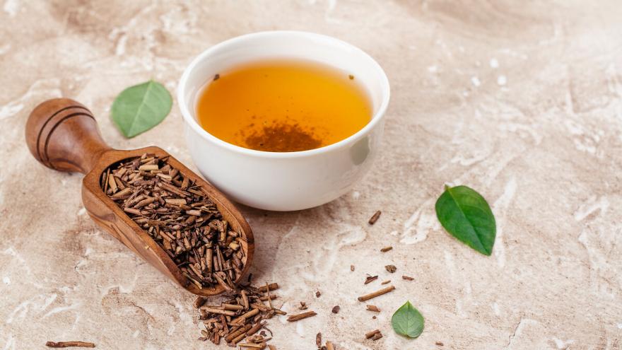 Teetasse und Löffel mit getrocknetem Tee