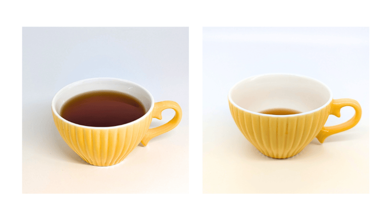 Zwei Tassen mit Algentee, links voll, rechts circa ein Drittel gefüllt.