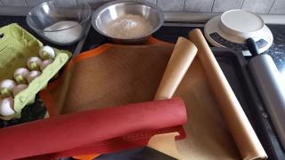 Auf einem Backblech liegen Backpapier und zwei Backmatten.