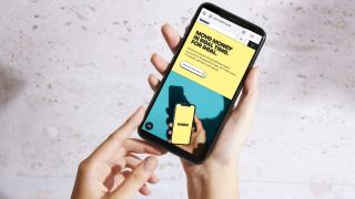 Zwei Hände halten ein Smartphone, auf dem Display ist die Internetseite von Wero zu sehen