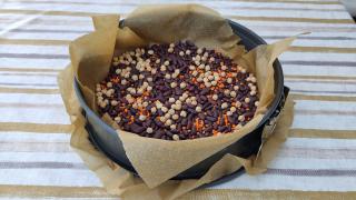 Kichererbsen, Bohnen und Linsen liegen in einer Kuchenform