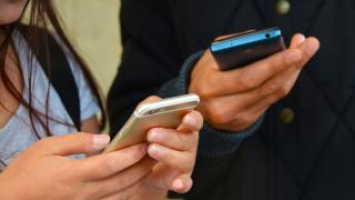 Nahaufnahme zweier Personen mit Smartphones in den Händen