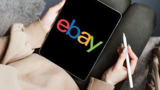 Tablet auf dem Schoß einer Person mit dem Logo "ebay" auf dem Display