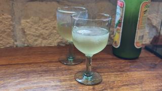 Zwei Weingläser mit Federweißer stehen neben einer Federweißer-Flasche.